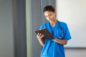 Nurse in blue uniform using a tablet