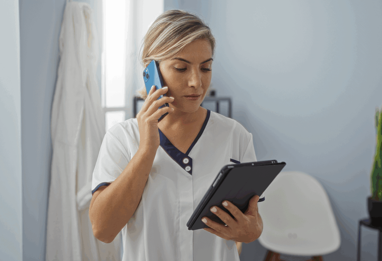 Healthcare professional on phone and tablet.