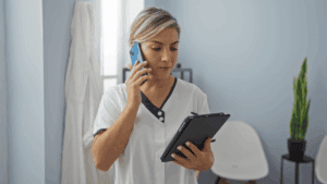 Healthcare professional on phone and tablet.