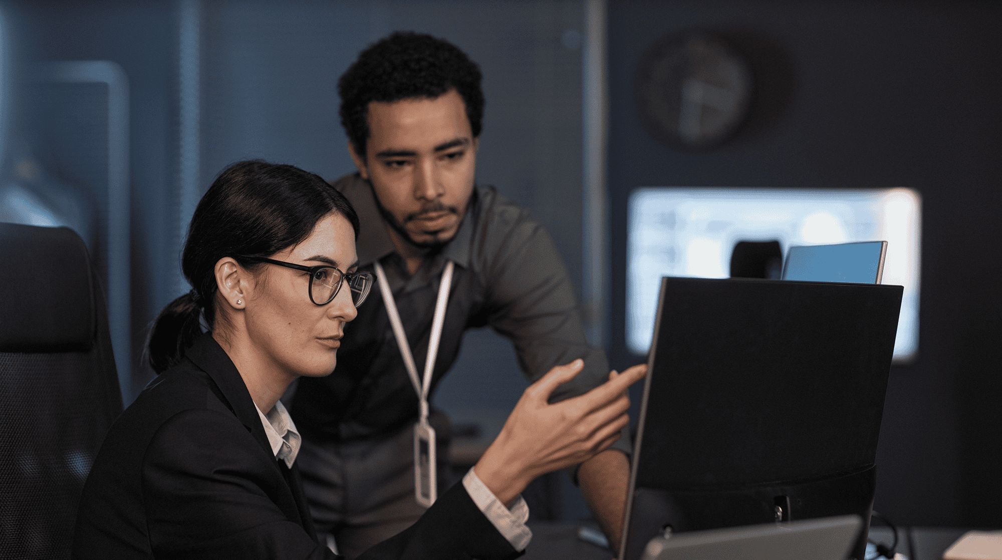 Two colleagues discussing work at computer.