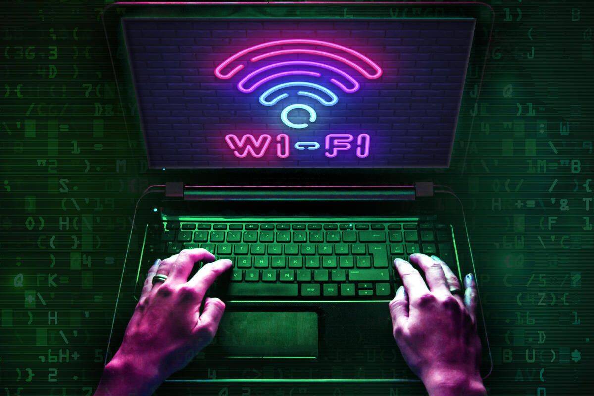 Hands typing on laptop with Wi-Fi symbol screen.