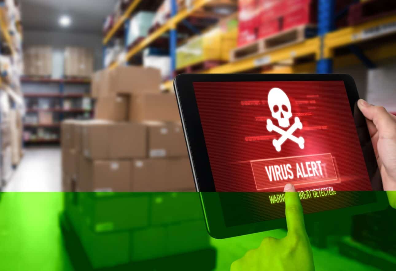 Tablet showing virus alert in warehouse.