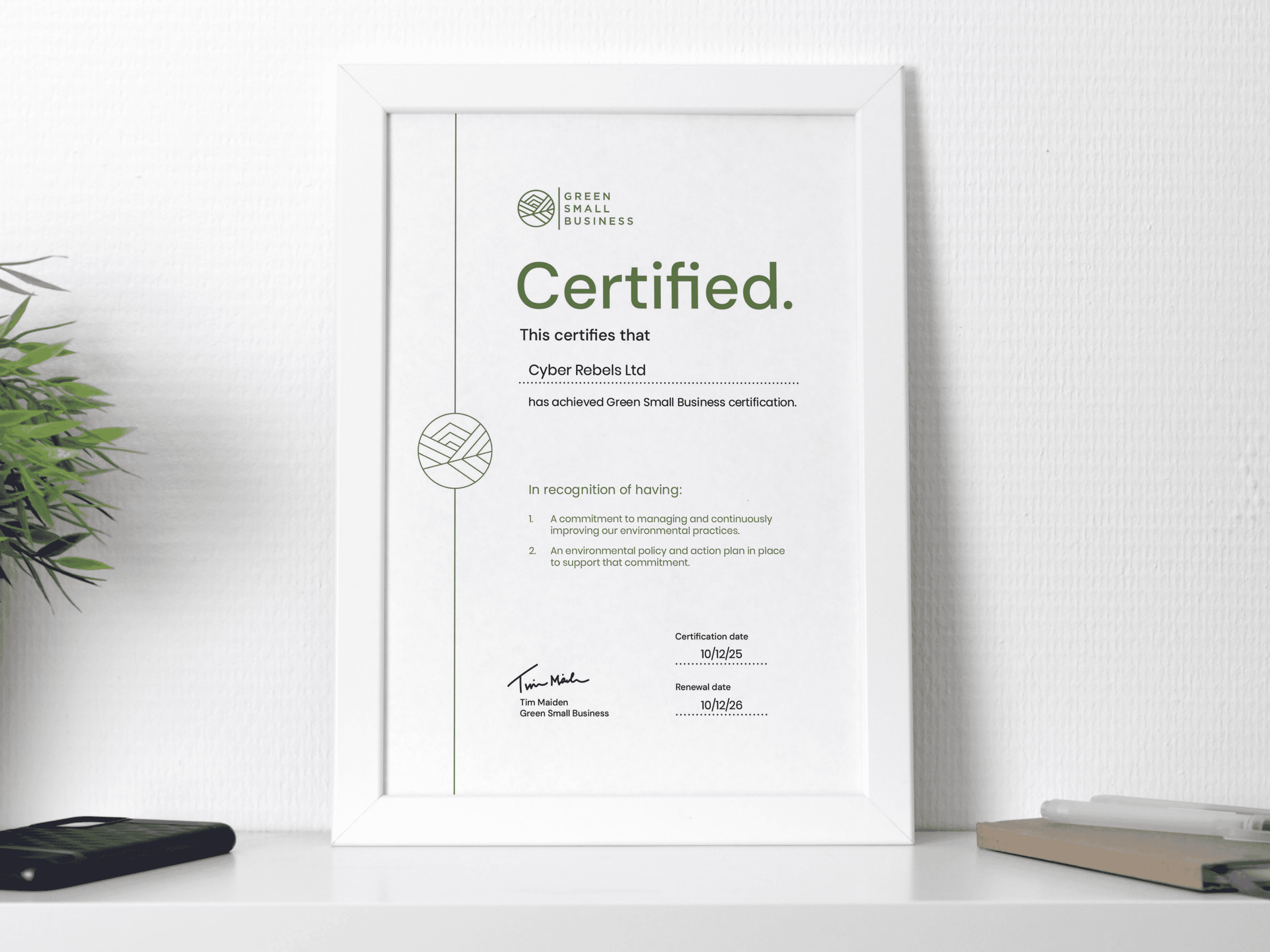 Certificate of Green Small Business achievement on shelf.